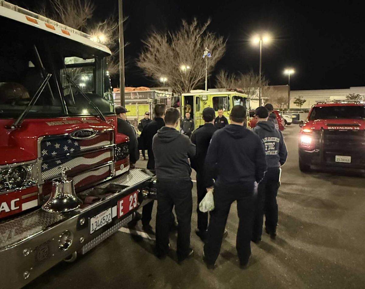 Members of a Sacramento-area firefighting strike force review plans before driving to Los Angeles to help battle several fires that are burning in the region.