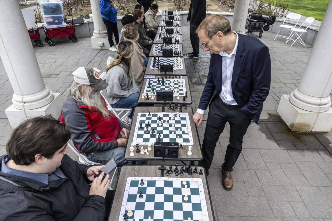 Patrick Wolff, a candidate for California Insurance Commissioner, takes a moment to consider a move against Clarence Lehman, of Garden Valley, during a chess game at Capitol Park on Tuesday. Wolff was playing speed chess against nine people at once in a bid to connect with potential voters.