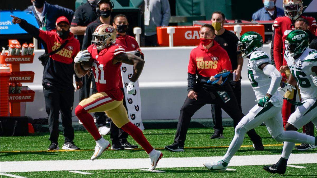 Raheem Mostert runs away from New York Jets defenders for a 49ers touchdown Sunday in East Rutherford, N.J.