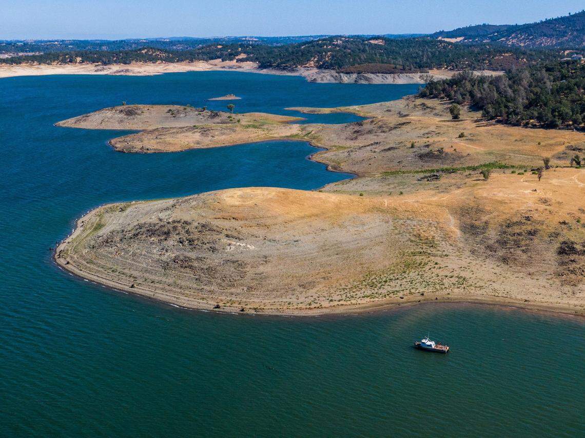 A boat floats near exposed lakebed at Folsom Lake on Tuesday, June 8, 2021, when the lake’s surface elevation was 396 feet. The lake has risen almost 20 feet since January, but it was almost fifty feet higher a year ago on this date. 