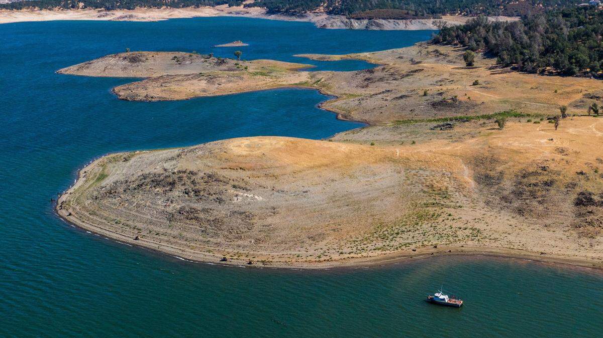 A boat floats near exposed lakebed at Folsom Lake on Tuesday, June 8, 2021, when the lake’s surface elevation was 396 feet. The lake has risen almost 20 feet since January, but it was almost fifty feet higher a year ago on this date.