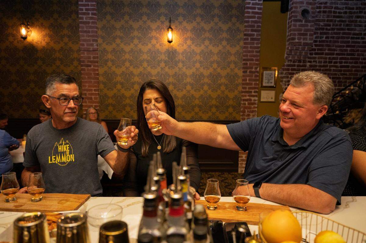 Customers Troy and Tracey Wickhan toast with Richard Saldivar, left, visiting from Tucson, Ariz., at the bar in Daniello’s speakeasy in Roseville on Friday.