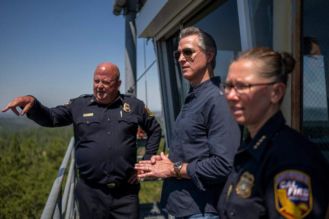 Gov. Gavin Newsom stands atop a fire watch tower with Cal Fire Nevada-Placer Unit Chief Brian Estes, left, and Cal Fire Chief Deputy Director Anale Burlew after a Tuesday press conference in Colfax on the federal government’s role in wildfire prevention.