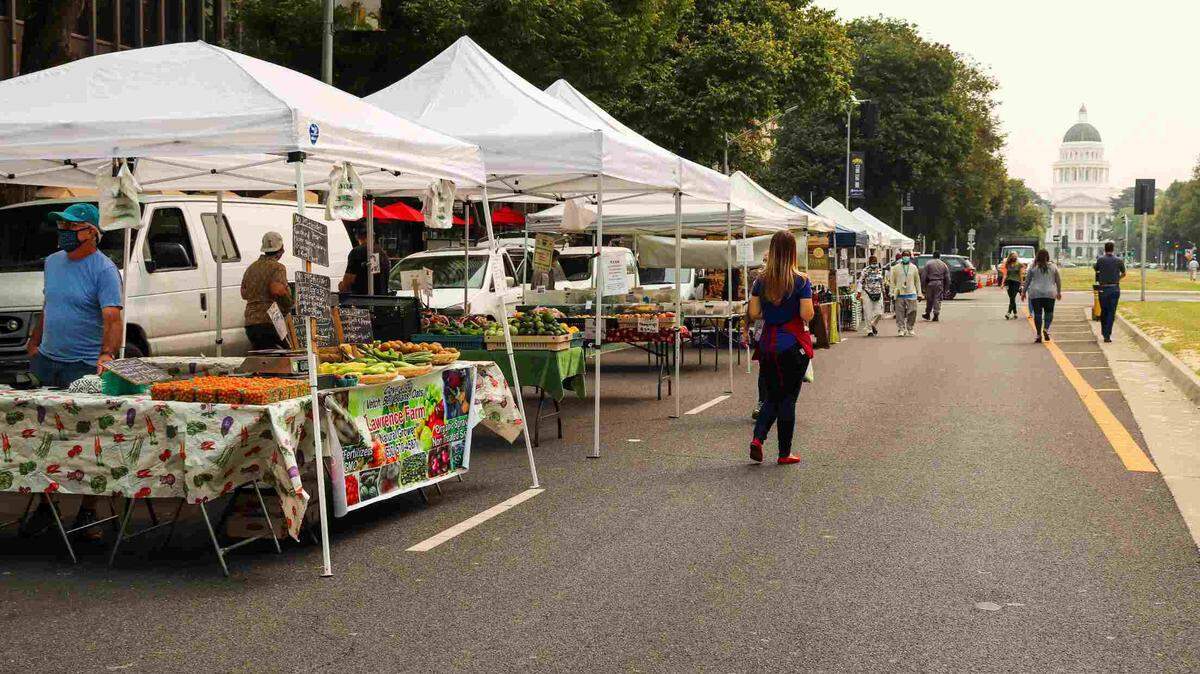 Vendors line an empty street in Sacramento. A pair of downtown Sacramento Certified Farmers Markets return for the summer season with produce, food vendors and more beginning Wednesday.