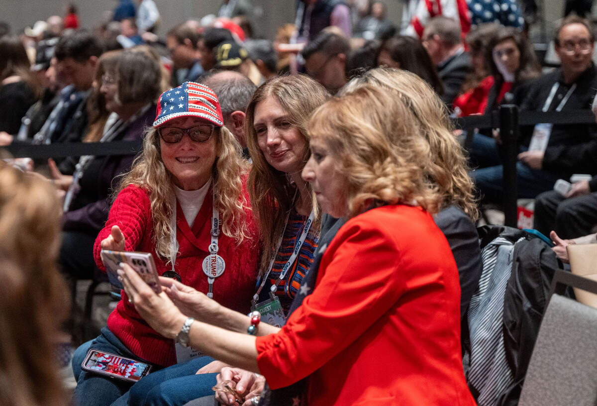 Republicans Robin Ellis, left, Sharie Abajian, center and Barbara Moore, take selfies at the CAGOP spring Convention in Sacramento on Sunday.