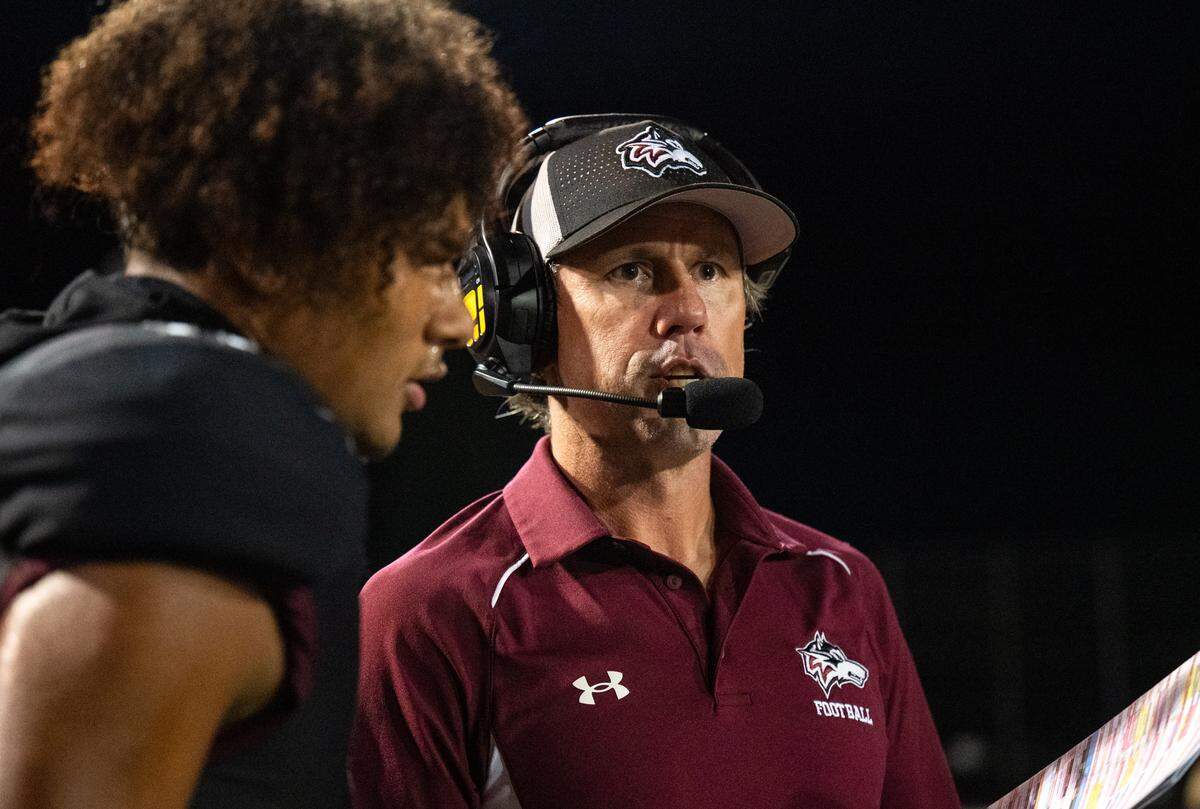 Woodcreek coach Kyle Stowers looks over the game plan with receiver Jack Torrey (11) in the second half against Inderkum on Friday in Roseville. 
