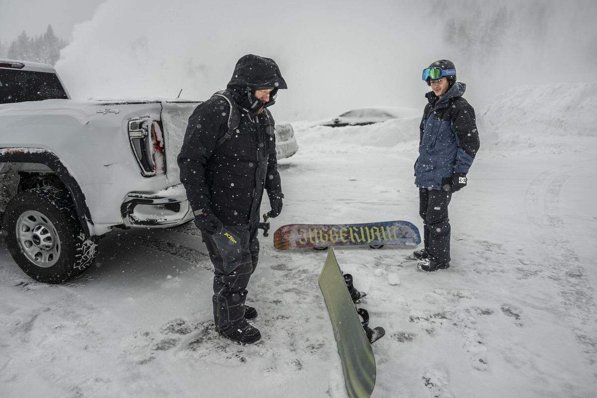 Justin Kucera, of Chilcoot, and his 14-year-old son Sawyer prepare to snowboard at Boreal Mountain Resort as recovery efforts continued for avalanche victims at nearby Castle Peak on Wednesday morning.