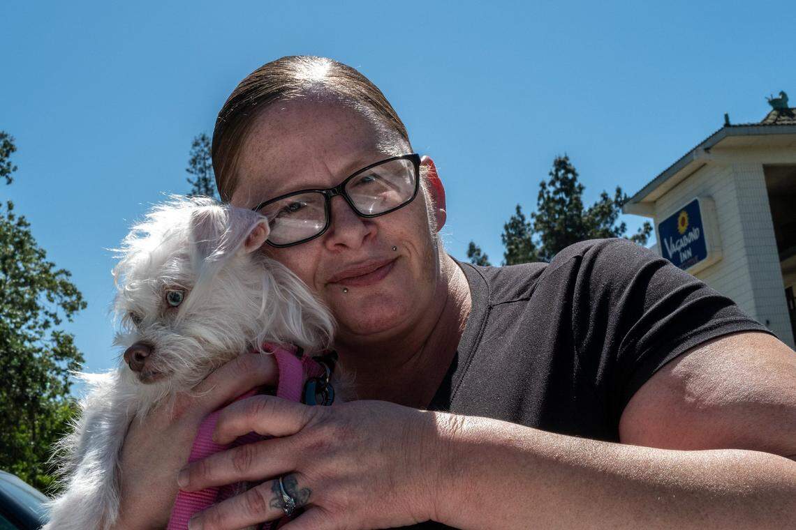 Project Roomkey participant Amber Box-Matson, 37, gets teary-eyed with her dog Aphrodite outside the Vagabond Inn motel in Sacramento on Wednesday. With the program at the motel ending, she said she called many of the numbers on a list of potential housing options provided by county officials. She said there were no openings.