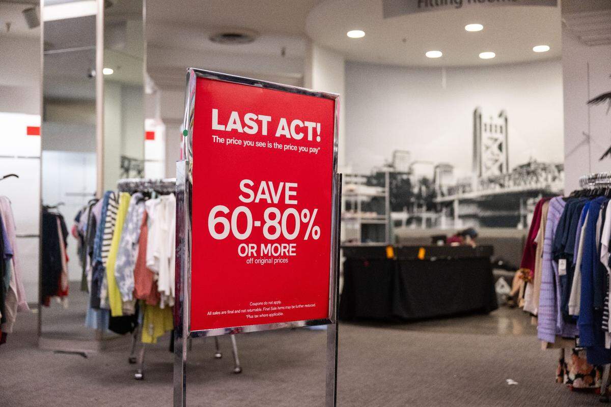 The Tower Bridge looms behind a sign displaying savings for customers at the Downtown Commons Macy’s store in Sacramento on Thursday.