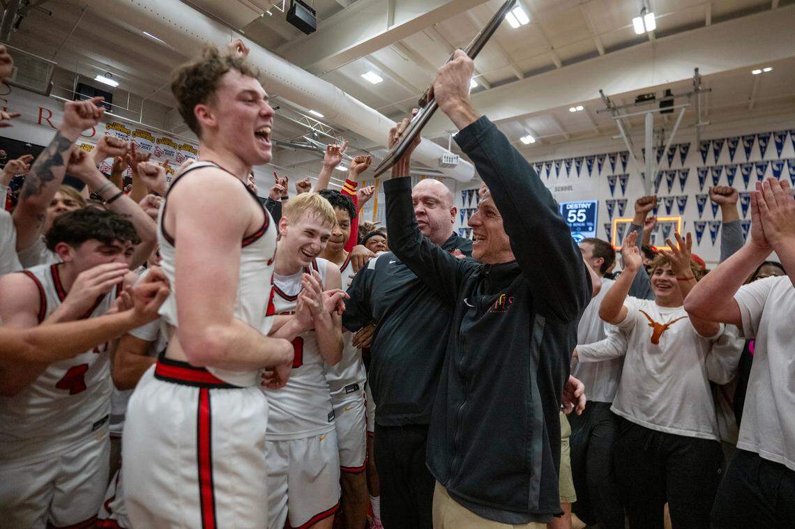 Jesuit Marauders head coach Tim Kelly holds up the CIF Northern California Division II boys basketball championship trophy with his team following the 65-55 victory over the Destiny Christian Lions on Tuesday.