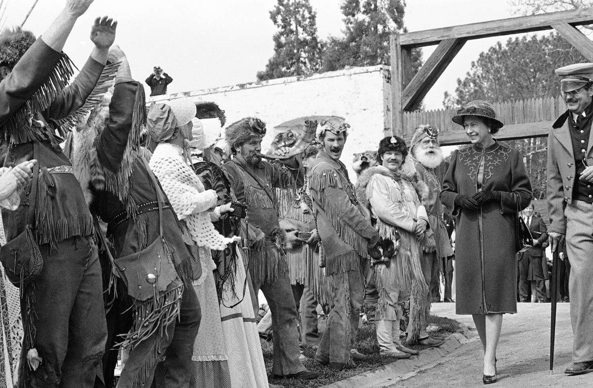 The Kit Carson Mountain Men greet Queen Elizabeth with yells and horns as she leaves Sutter Fort following her tour.