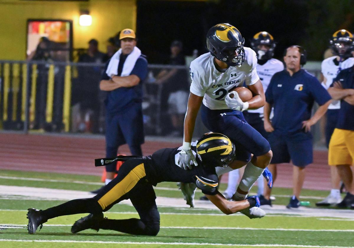 The Oak Ridge Trojans’ Kaleb Edwards (21) runs the ball before being tackled by the Del Oro Golden Eagles’ Beaux Sauve (10) on Friday in Loomis.