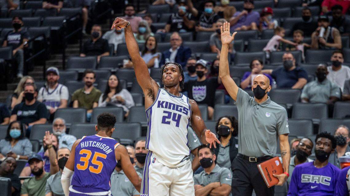 Buddy Hield makes a 3-pointer basket as Sacramento Kings assistant coach Doug Christie raises his hand during the second half against the Phoenix Suns on Monday, Oct. 4, 2021.