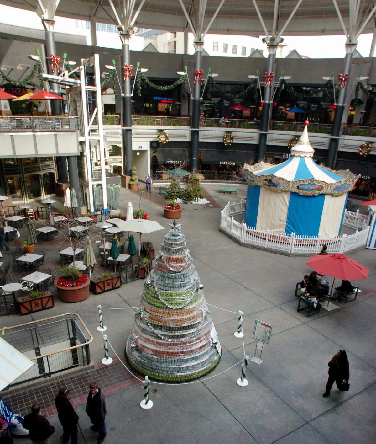 Shoppers walk through the center courtyard between Macy’s and the movie theater in Downtown Plaza near a canned food donation tree in 2007.