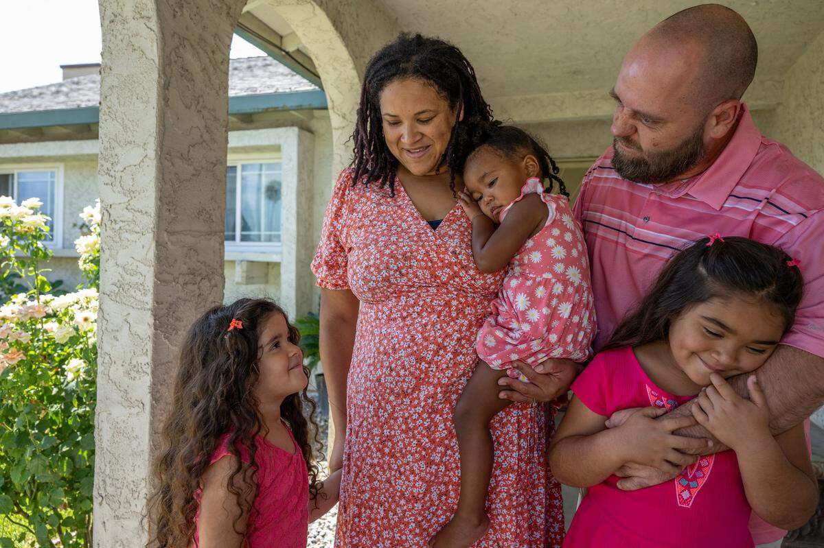 Anailicia Bates, 4, left, looks up at her mom Destinee Campbell, holding daughter Marielena Bates, 2, and dad Larry Bates, embracing daughter Nayelieden Bates, 6, at their home in Rio Linda on Aug. 11. Nayelieden was born by C-section but Campbell’s two other children were born VBAC.