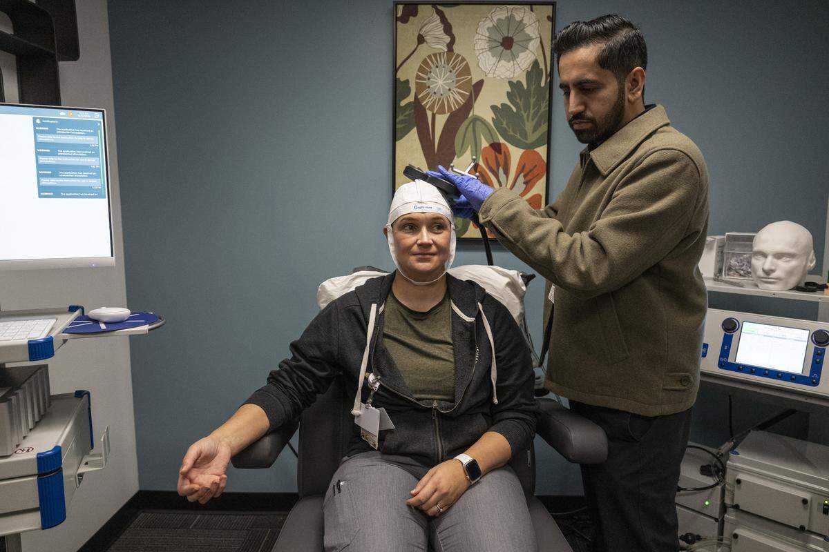 Dr. Hammad Khan, director of interventional psychiatry for Sutter Health, right, demonstrates a new accelerated treatment for depression known as SAINT at the Sutter Center for Psychiatry in Sacramento on Monday, Dec. 8, 2025. Sutter Health will be the only health system in the Sacramento region to offer the accelerated transcranial magnetic stimulation.