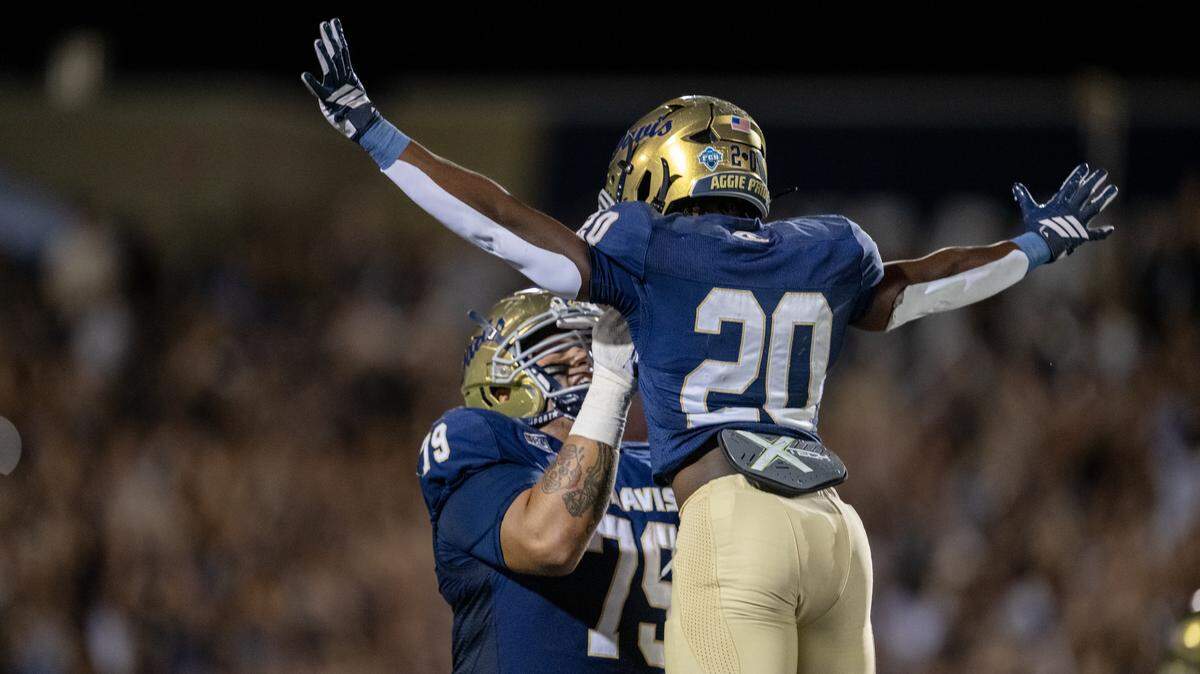 UC Davis Aggies offensive lineman Ernesto Nava lifts running back Jordan Fisher into the air after Fisher scored a touchdown in the second half against the Southern Utah Thunderbirds on Saturday in Davis.