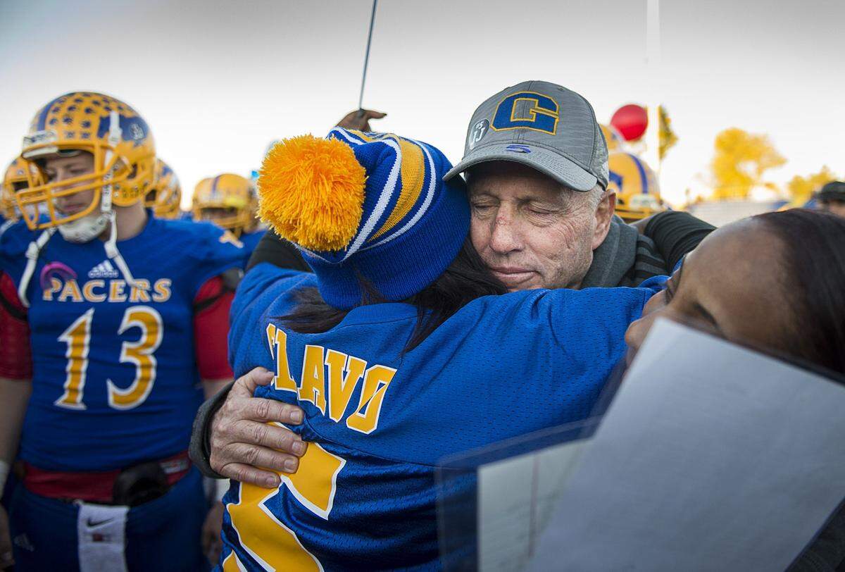 Grant High School coach Mike Alberghini hugs Nicole Clavo, mother of JJ Clavo, before the team’s rescheduled first-round home playoff game against Beyer High School on Monday, Nov. 16, 2015. Grant player JJ Clavo was fatally shot Friday during an off campus trip to get food before the game’s originally scheduled start on Friday.