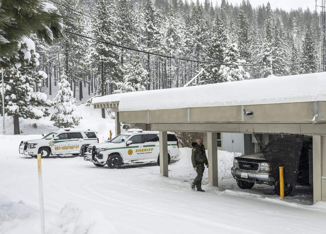 A Nevada County Sheriff’s deputy walks outside the Truckee substation on Wednesday. Law enforcement are using the station as a staging ground as they continue to search for and recover skiers caught in Tuesday’s avalanche.