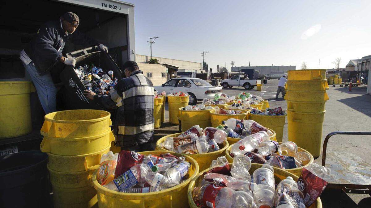 Workers unload cans and bottles at Ming’s Recycling in south Sacramento in 2012. The company shuttered its 47th Avenue bottle and can buyback site, saying aggressive state regulations and enforcement led to long lines and angry customers.