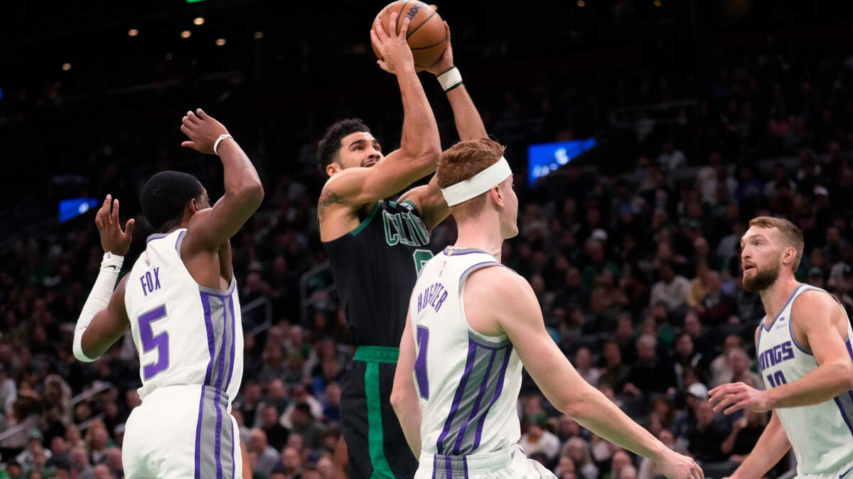 Boston Celtics forward Jayson Tatum (0) drives through the Sacramento Kings during the first half of an NBA basketball game on Friday in Boston.