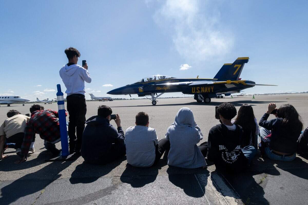 Mills Middle School teacher Jason McKnight waves to his students before his flight with Blue Angels pilot Maj. Scott Laux at Mather Airport on Tuesday.