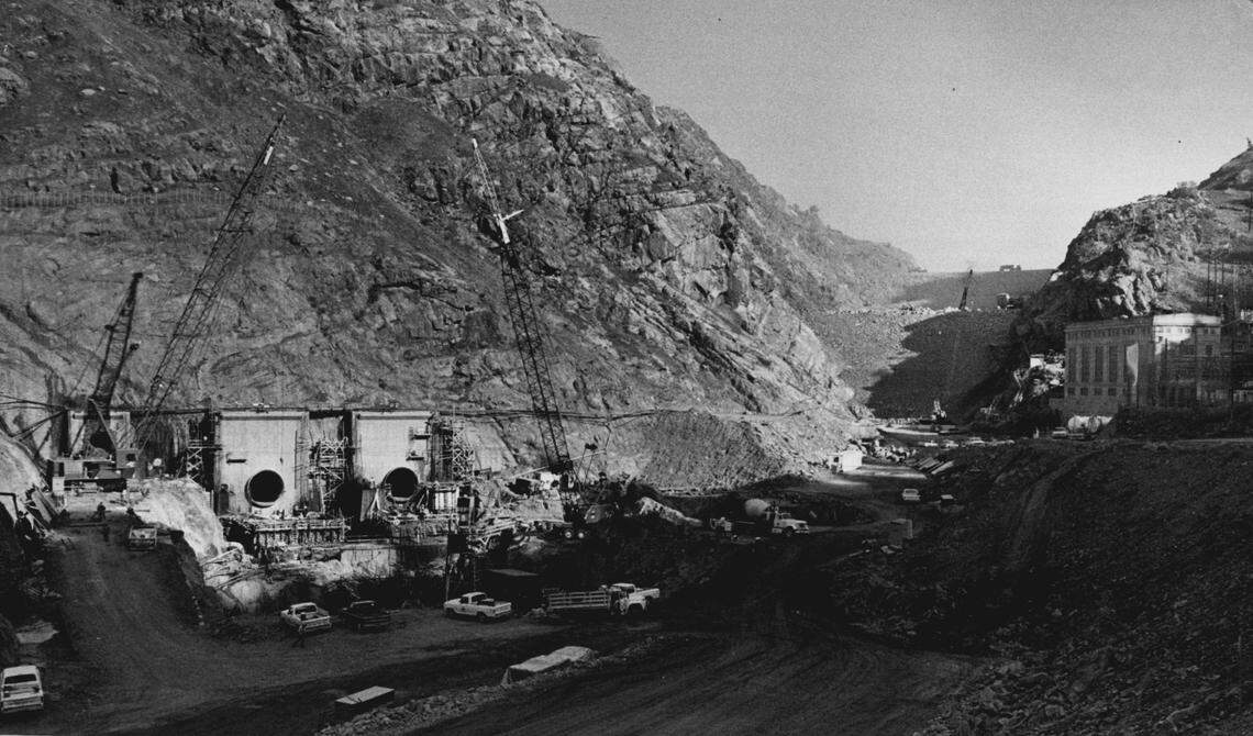 The New Melones Dam, to be the second-highest earth filled dam in California when completed, is under construction on Dec. 15, 1976. At left are two large power tunnels for the project’s hydroelectric plant and a smaller tunnel designed for flood control and irrigation uses.