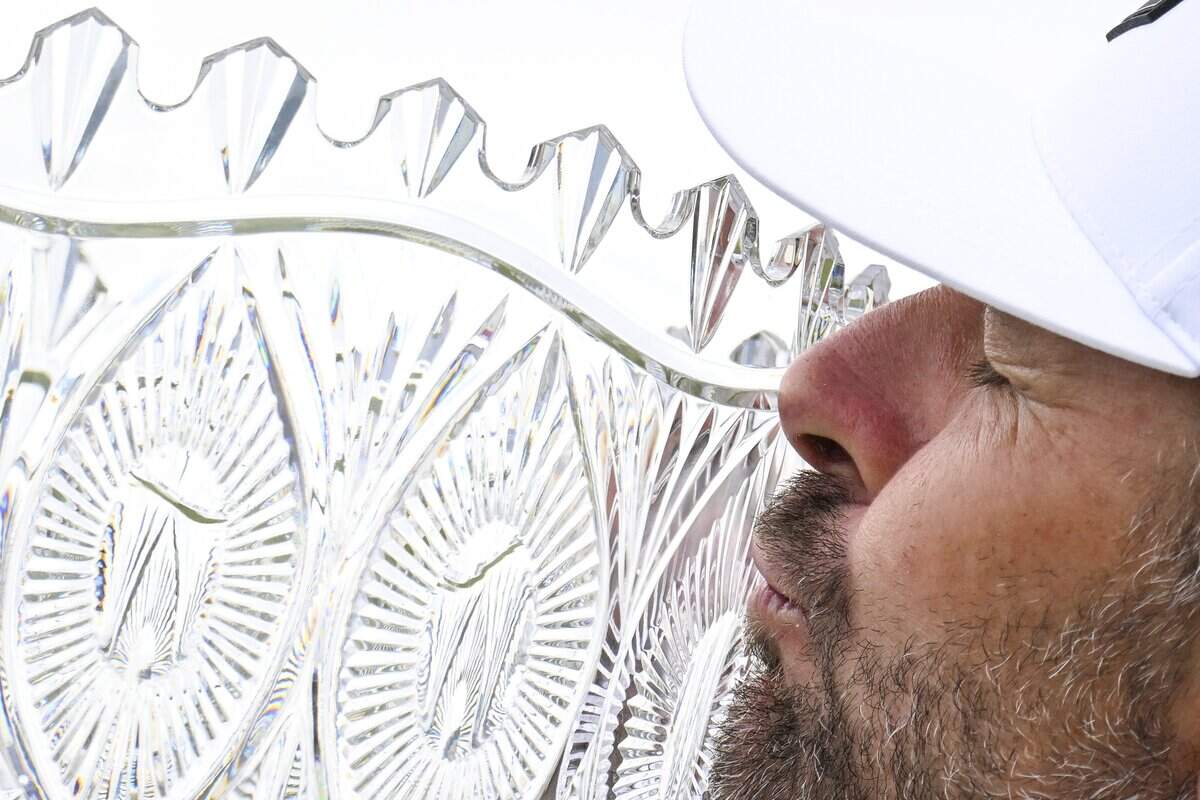 Former professional tennis player Mardy Fish kisses the trophy after winning the American Century Golf Tournament in Stateline, Nev. on Sunday.