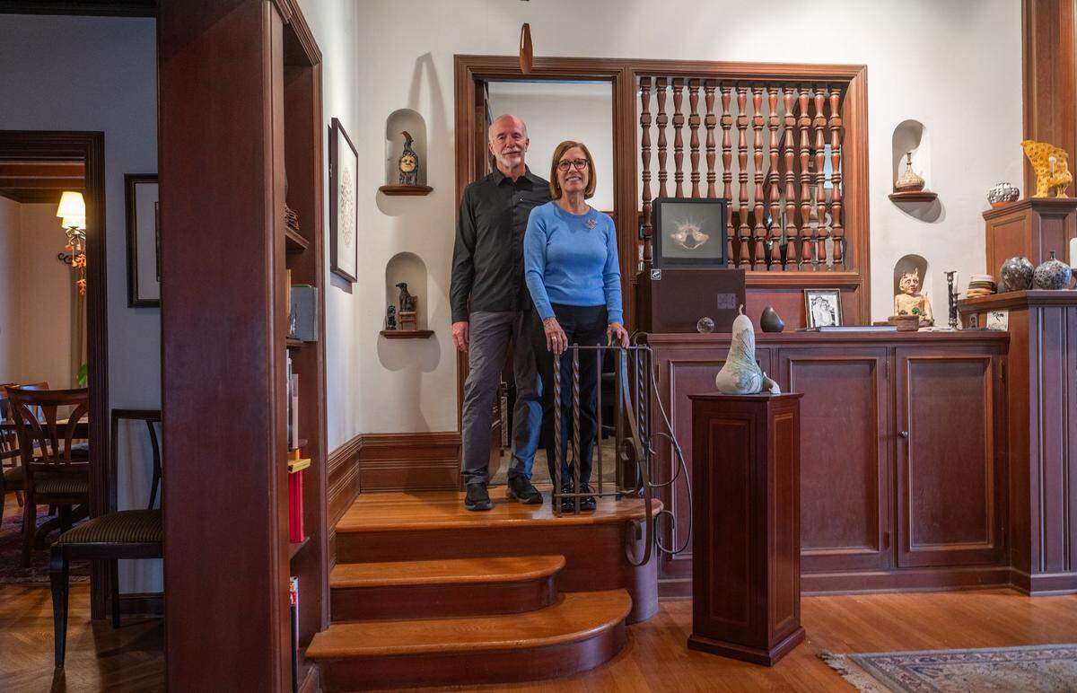 Peter Saucerman and Susan Twining pose earlier this month atop steps that appear in old photographs from noted architect Leonard F. Starks’ parties. Twining said it was fun to look through the pictures and see their home 90 years ago. The staircase leads to Starks’ old office and studio Twining now works in. 