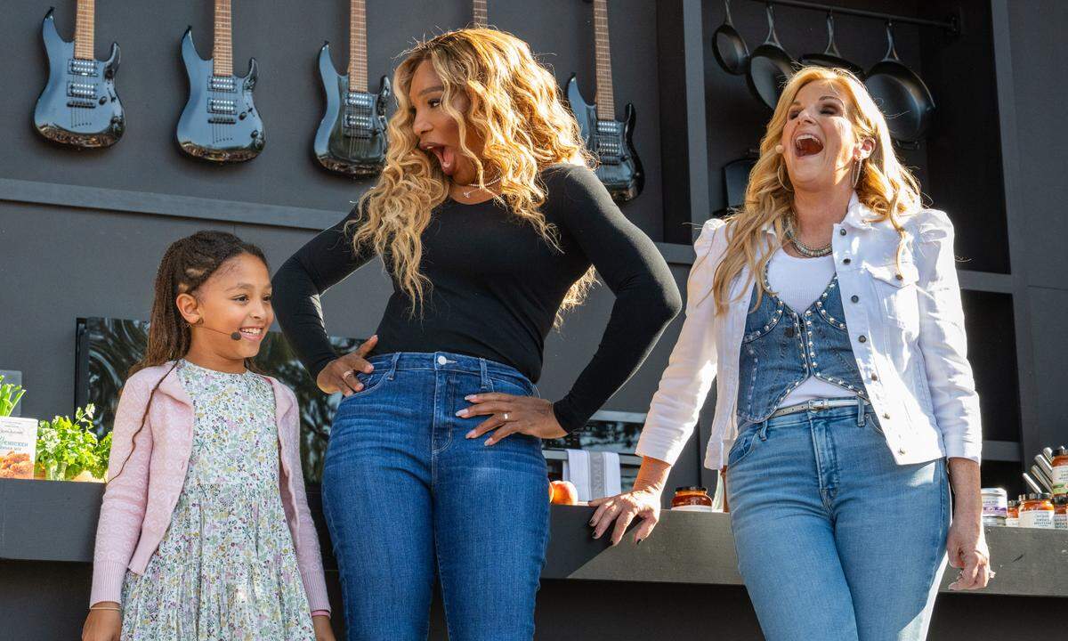 Tennis star Serena Williams and county music star Trisha Yearwood laugh as Williams’ daughter Olympia is introduced before a cooking demonstration at the BottleRock music festival in Napa on Friday, May 23, 2025. 