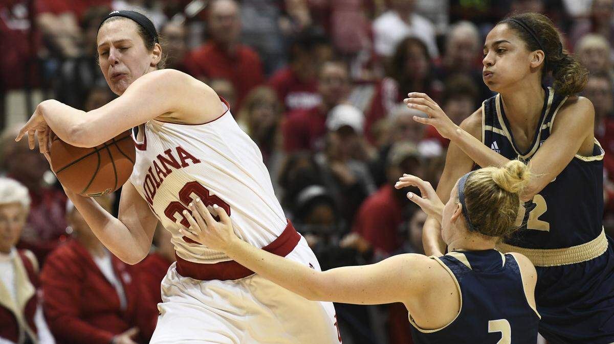 Indiana forward Amanda Cahill, left, is fouled by UC Davis guard Kourtney Eaton, center, during an NCAA college basketball game in the women's NIT in Bloomington, Ind. Sunday, March 25, 2018. Indiana won 81-66.