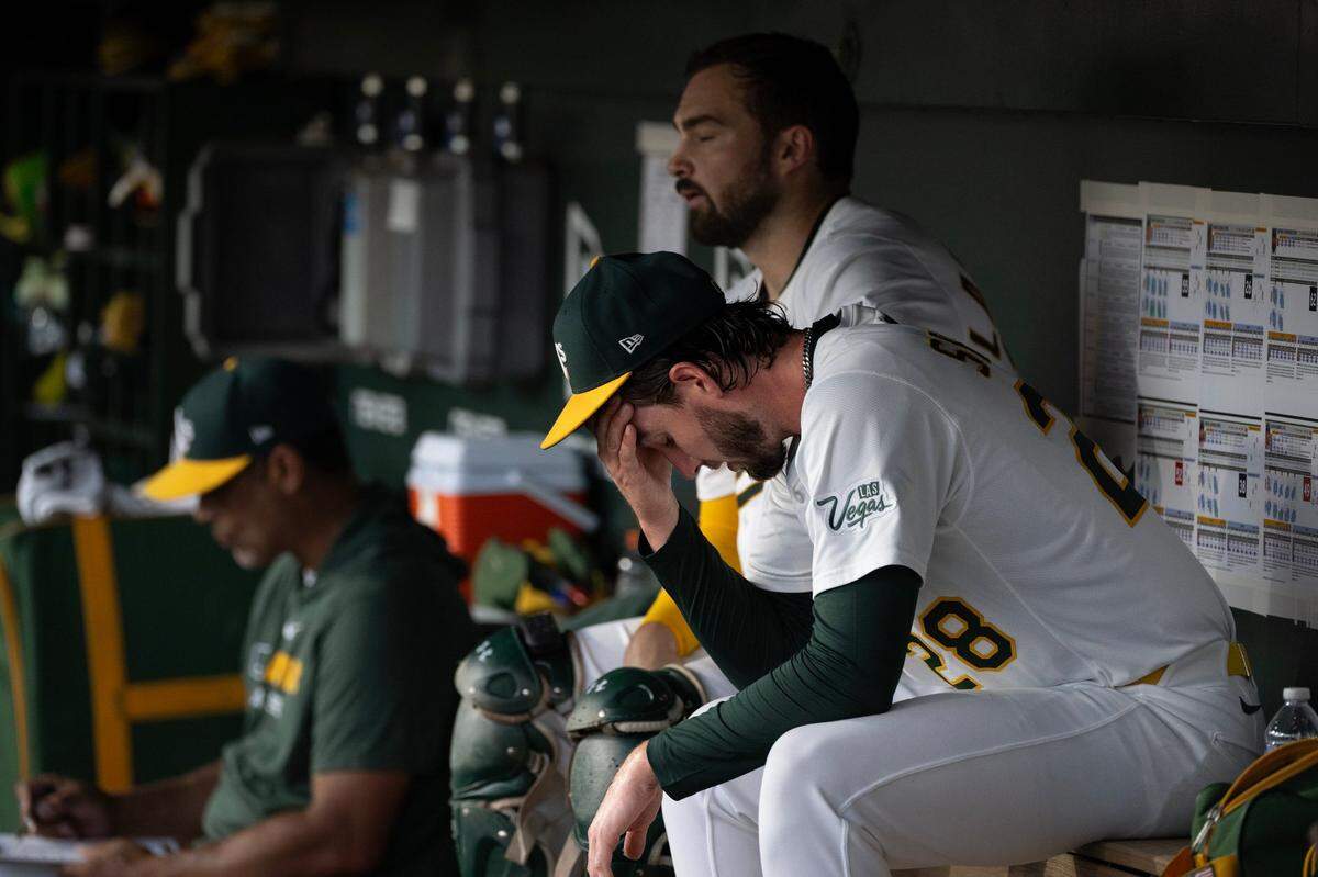 Athletics pitcher Mitch Spence (28) sits in the dugout in the bottom of the fifth inning during the game against the Atlanta Braves on Wednesday at Sutter Health Park in West Sacramento.