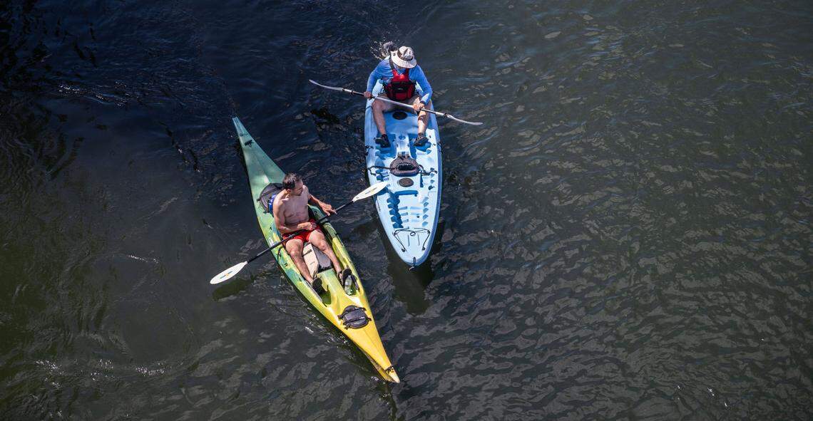 Patrick Walber, of West Sacramento and Maurice O’Conner of Rancho Cordova ride their kayaks on the American River in Carmichael on Thursday, June 27, 2024. Weather forecast warns of triple digits temperatures starting July 1. 