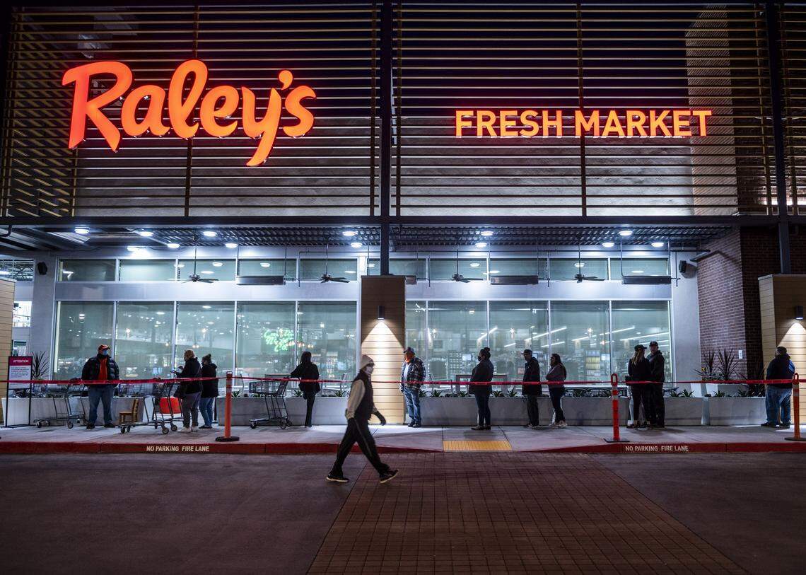 Customers wait in line early Wednesday morning outside the new Raley’s in South Land Park on opening day, April 15, 2020.
