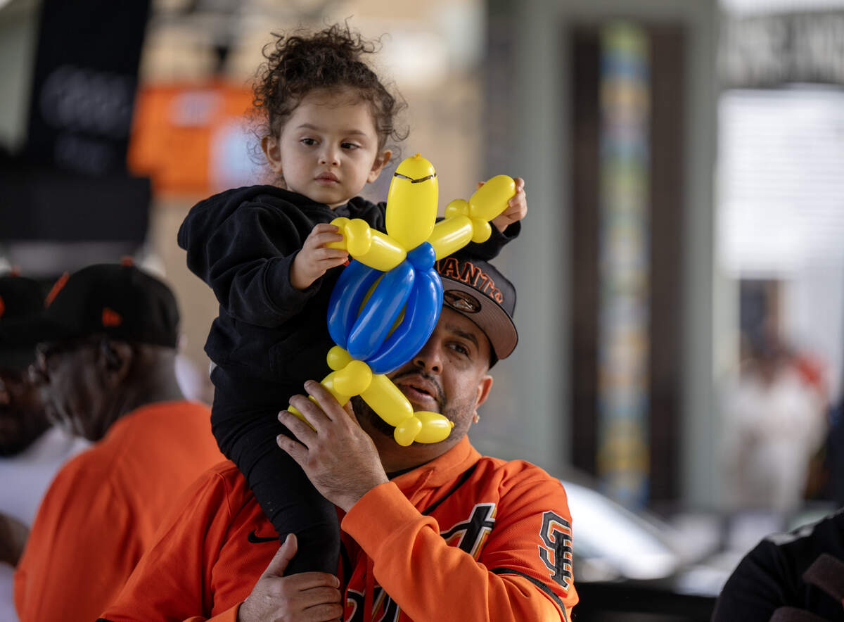 Isaac Bermudez holds his daughter Melina at the San Francisco Giants FanFest at Sutter Health Park on Saturday in West Sacramento.