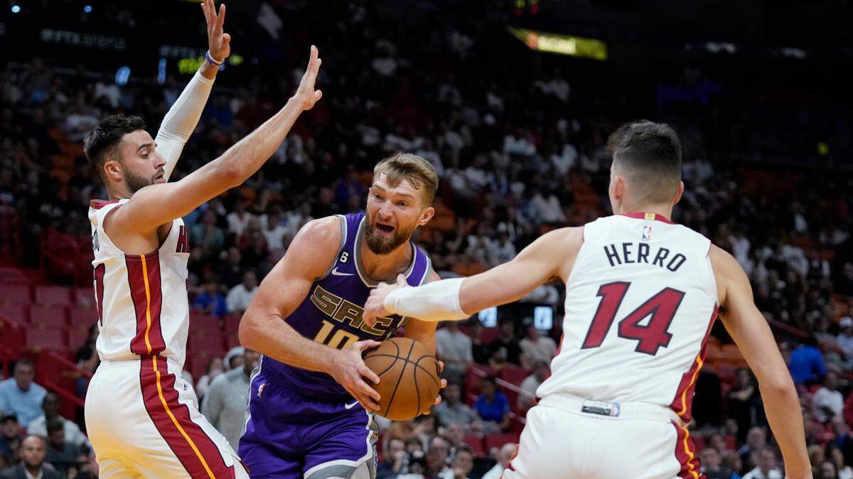 Sacramento Kings center Domantas Sabonis (10) looks for an opening past Miami Heat guards Tyler Herro (14) and Max Strus during the first half of an NBA basketball game, Wednesday, Nov. 2, 2022, in Miami. (AP Photo/Wilfredo Lee)