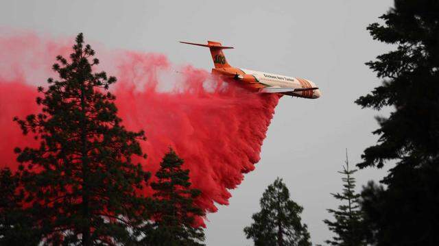 An Erickson Aero Tanker drops fire retardant on the Park Fire on Monday. In a Friday operational update, firefighters said the blaze has become the fourth-largest wildfire in California history.