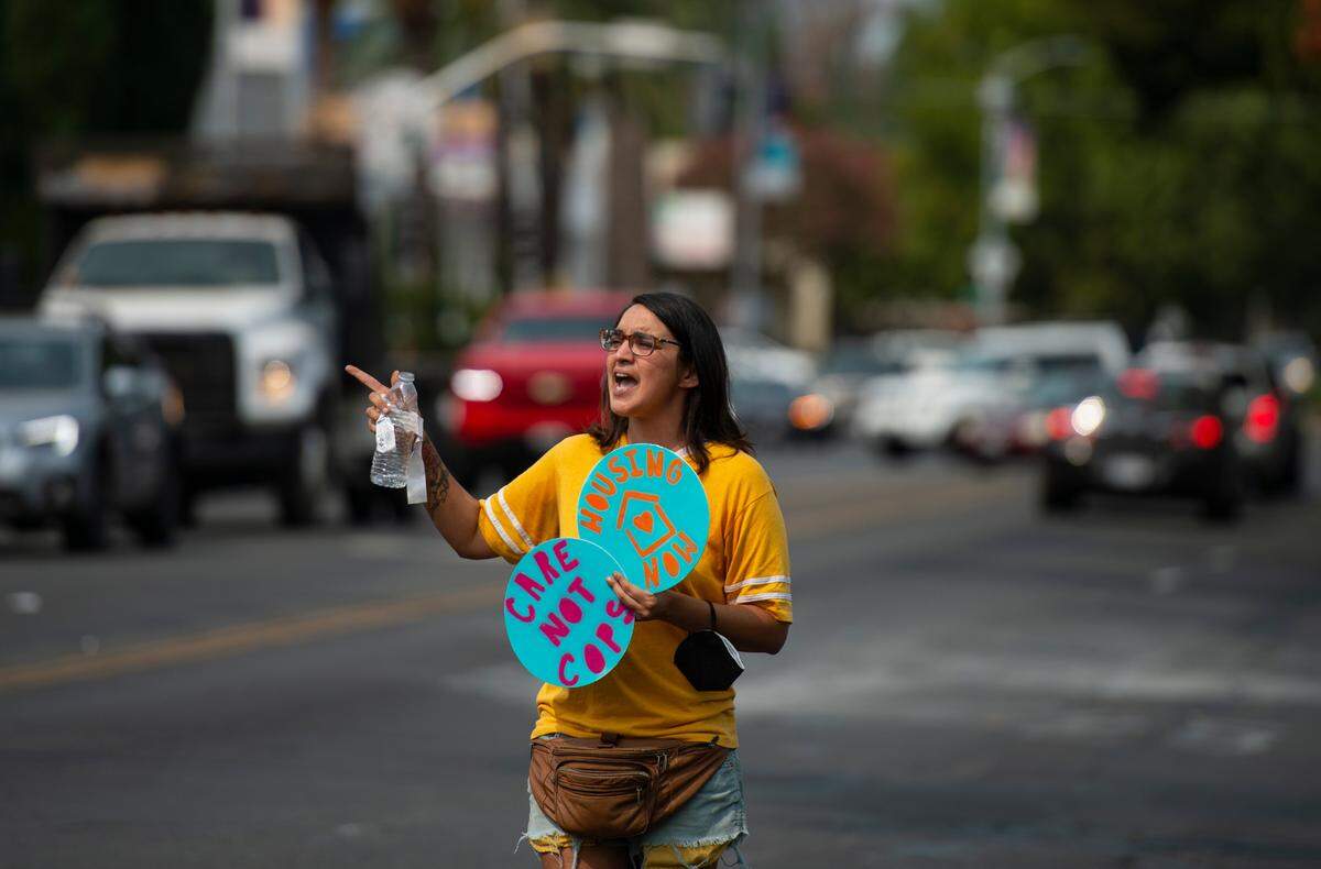 Homeless activist Niki Jones shouts across the intersection of Broadway and Land Park Drive at a group calling for increased policing Saturday.
