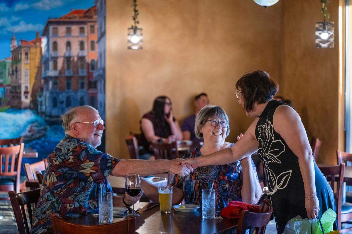 Carol Mar, right, celebrating her 70th birthday, meets Dan Brown, left, celebrating his 71st birthday with his wife Kathy Moore, at Ippolito’s Trattoria in Rosemont earlier this month.