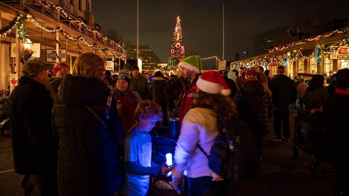 A crowd gathers on K Street in Old Sacramento to watch a live performance of a Theatre of Lights performed on the balconies Saturday, Dec. 18, 2021.