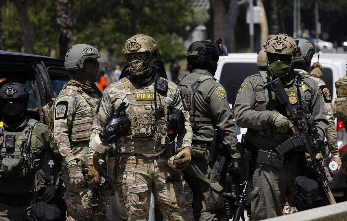 Armed and masked federal immigration agents are seen near MacArthur Park in the Westlake area of Los Angeles.