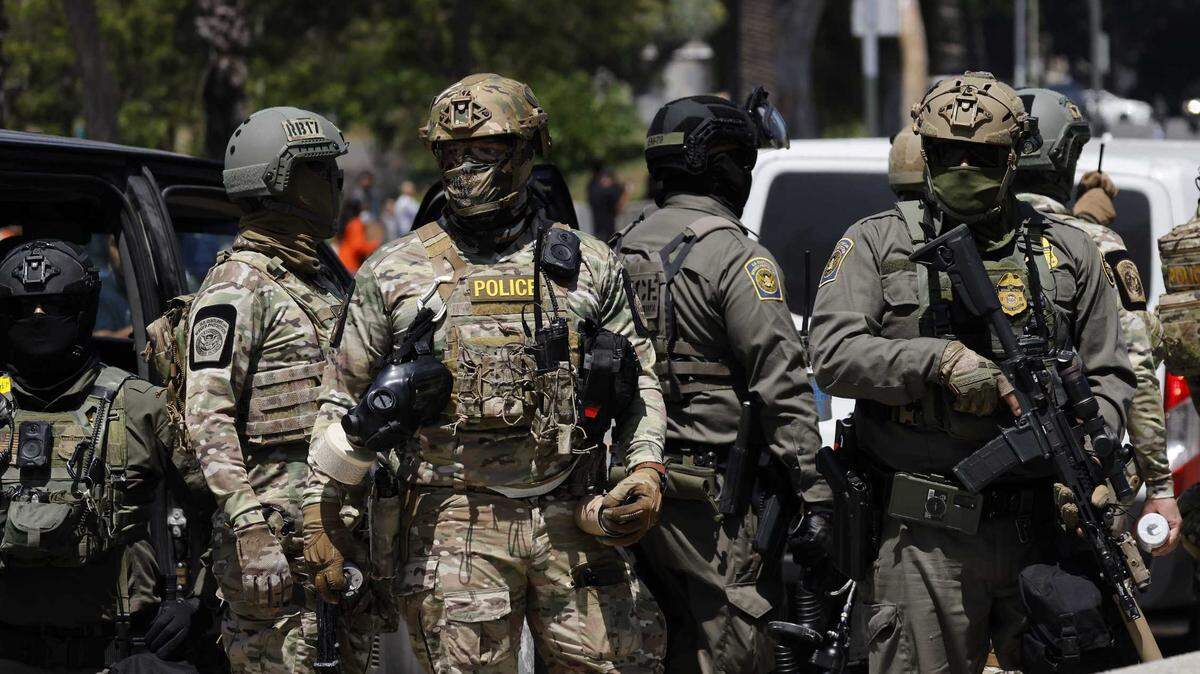 Armed federal immigration agents are seen near MacArthur Park in the Westlake area of Los Angeles.