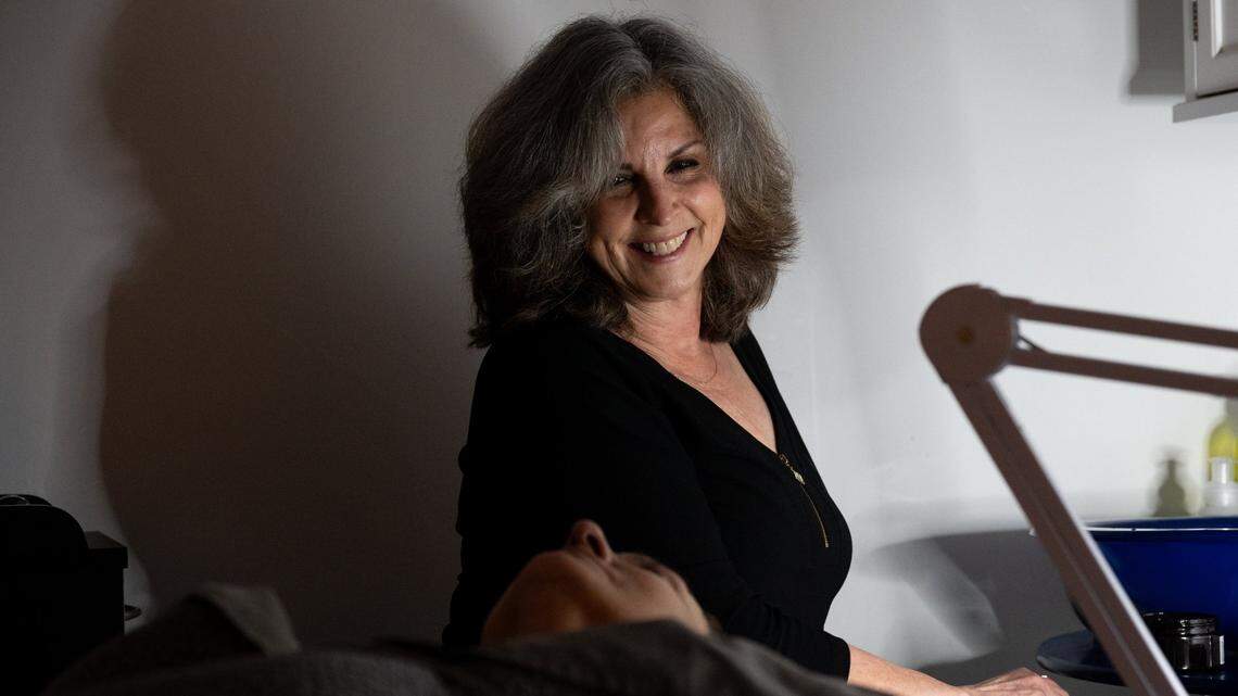 Self-employed cosmetologist Carol Dyer works with a client in earlier this month in Elk Grove. Dyer used to pay $853 a month in premiums for her health insurance, with a co-pay of $80 when she visited her primary care doctor. When she signed up for 2024 coverage with Covered California, her monthly premium dropped to $168, with $5 co-pays for a doctors visit.