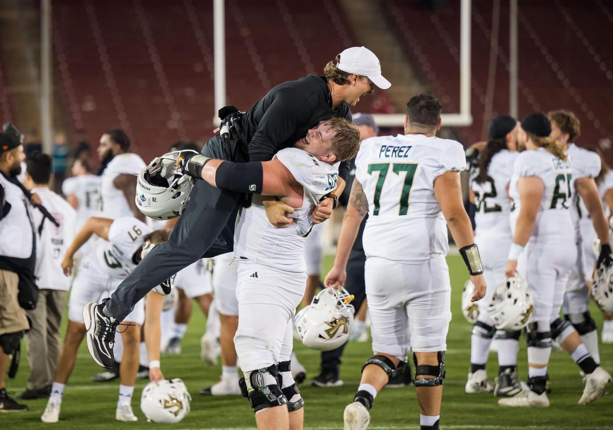 Sacramento State Hornets offensive lineman Jackson Slater (76) lifts up strength coach Nathan Morris as the team celebrates their 30-23 win over the Stanford Cardinal at the NCAA college football game Saturday, Sept. 16, 2023, at Stanford University.