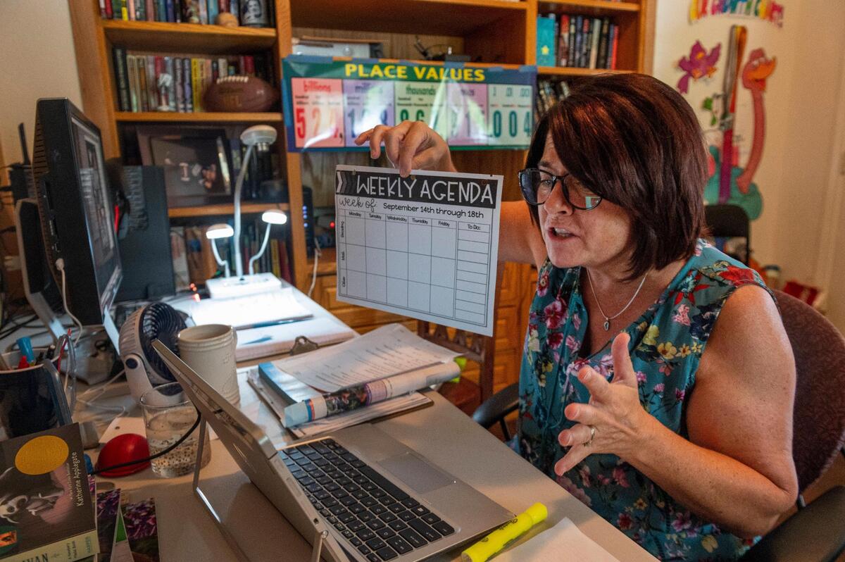 Amy Jacobsen, a fourth grade teacher at John Reith Elementary in Elk Grove, holds up the weekly agenda for her students while teaching her class remotely from her home in Elk Grove on Monday, Sept. 14, 2020, during the coronavirus pandemic.