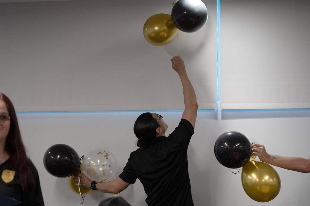 Anh-Tuan Pham helps take down balloons after his Reintegration Academy graduation at Sacramento State in May. He was often one of the first to help with setup and cleanup during the program, which supports formerly incarcerated individuals as they re-enter society.