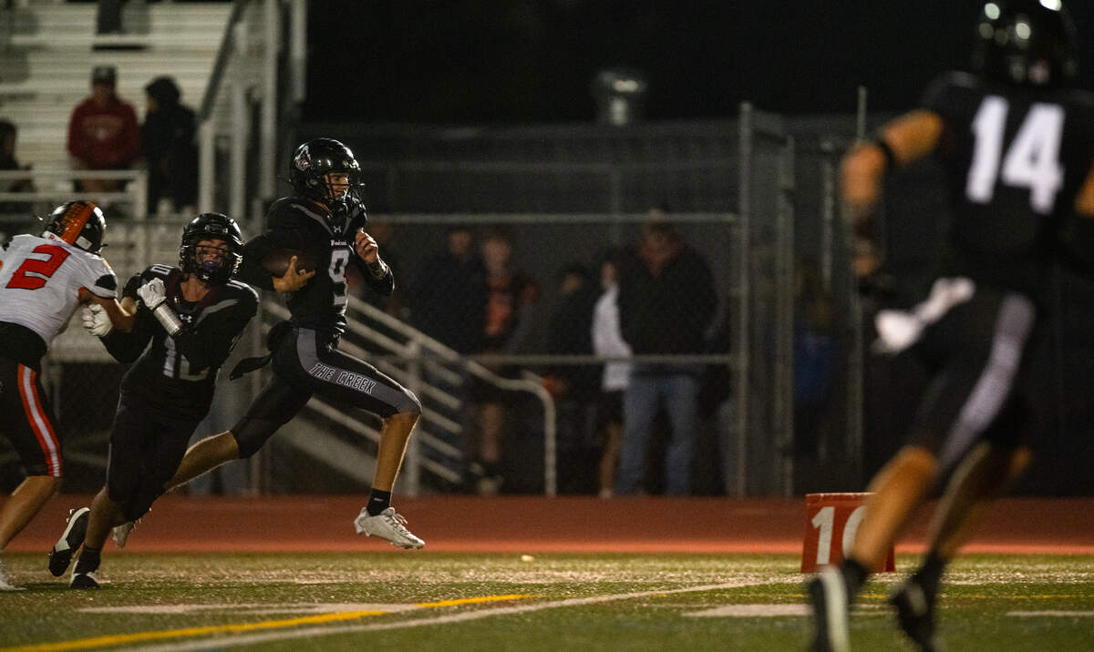 Woodcreek Timberwolves quarterback Austin Katapodis (9) escapes from pressure to scramble for a 41-yard touchdown against the Roseville Tigers at the start of the fourth quarter on Friday at Woodcreek High School in Roseville.