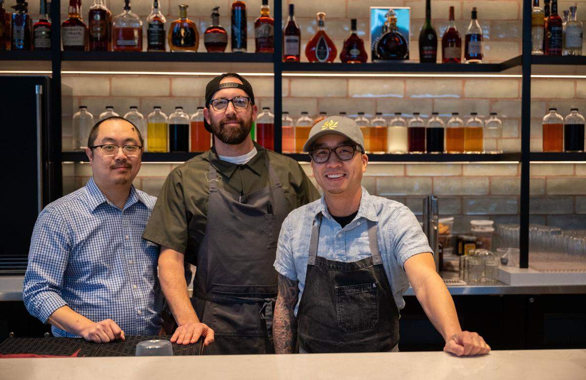 Chu Mai partners chef Tyler Bond, left, Michael Ng, center, and chef Billy Ngo stand behind the bar earlier this month. The restaurant features Asian and Southeast Asian cuisine.