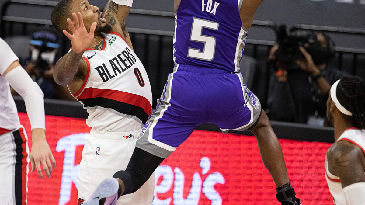Sacramento Kings guard De’Aaron Fox (5) drives to the basket past Portland Trail Blazers guard Damian Lillard (0) in the first quarter during a game at Golden 1 Center on Wednesday, Jan. 13, 2021 in Sacramento.
