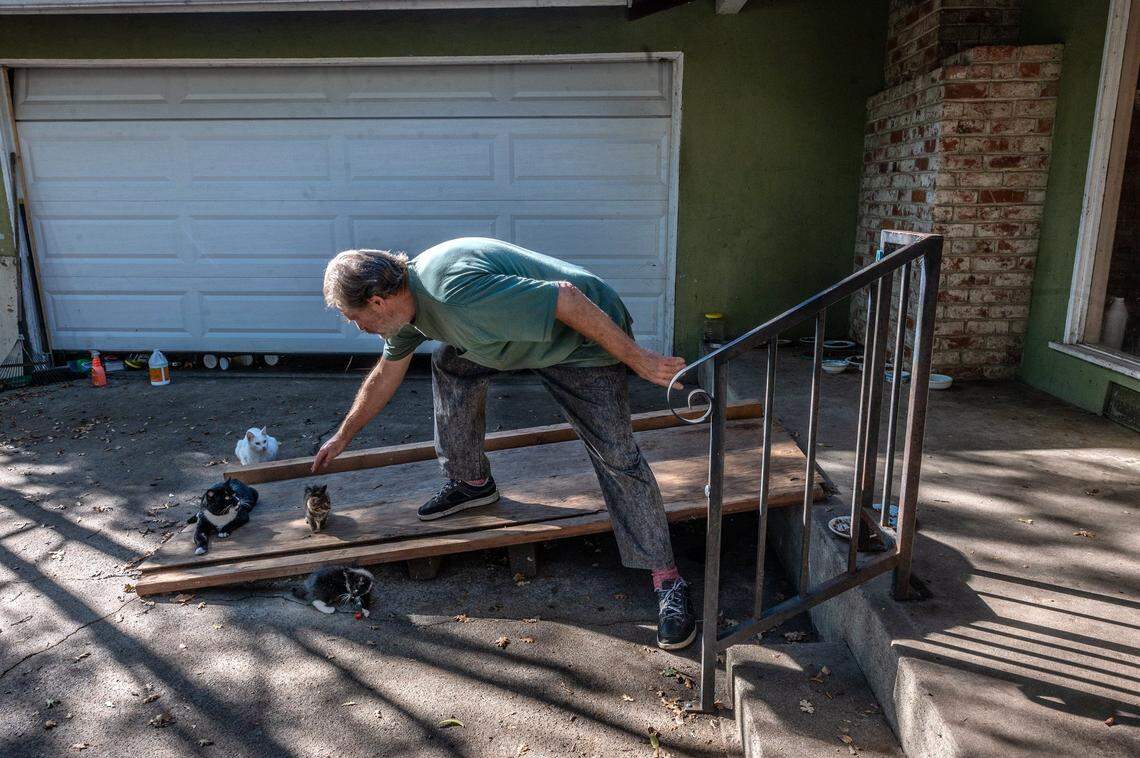 Bruce Siegrist, 66, pets one of the kittens he and his wife care for in front of their Sacramento home, now in receivership, in November. The city sued the Siegrists earlier this year, asking a judge to appoint a receiver for the home because of code violations. The appointed receiver now controls the property.